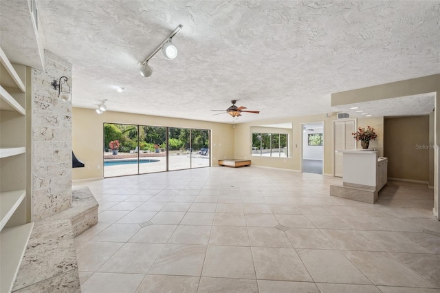 unfurnished living room with light tile patterned floors, track lighting, a textured ceiling, and a ceiling fan