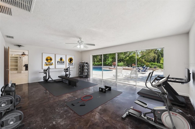 workout area featuring ceiling fan and a textured ceiling