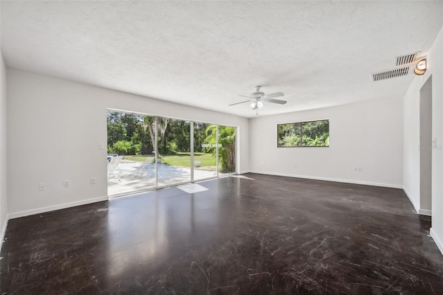 empty room featuring visible vents, a textured ceiling, concrete floors, baseboards, and ceiling fan