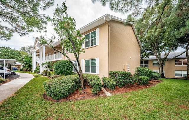 view of property exterior featuring a lawn and stucco siding