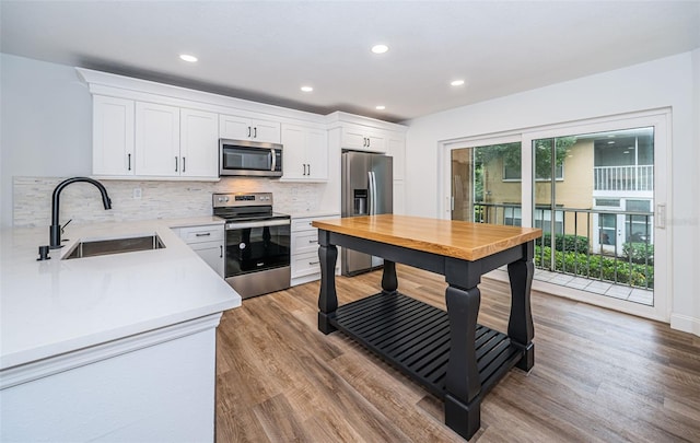 kitchen featuring light countertops, appliances with stainless steel finishes, a sink, and white cabinets