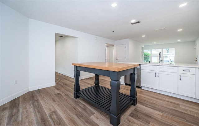 kitchen with white cabinets, light hardwood / wood-style floors, and sink