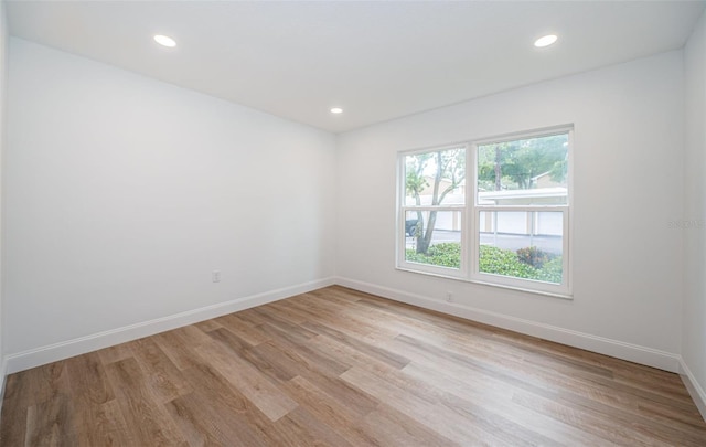 unfurnished room with recessed lighting, light wood-style flooring, and baseboards