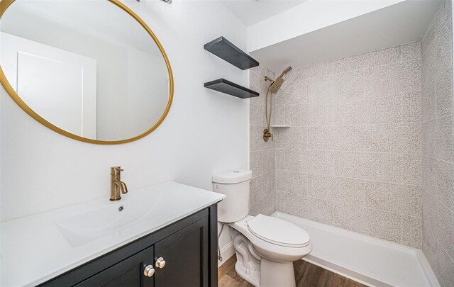 bathroom featuring a shower, vanity, toilet, and wood finished floors