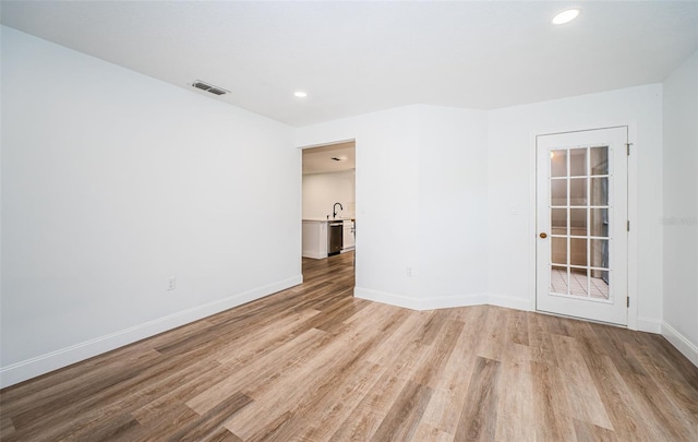 unfurnished room with light wood-style floors, baseboards, visible vents, and recessed lighting