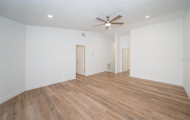 empty room featuring visible vents, baseboards, ceiling fan, vaulted ceiling, and light wood-style floors