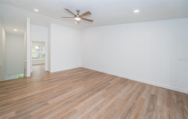 spare room with light wood-style floors, baseboards, and a ceiling fan