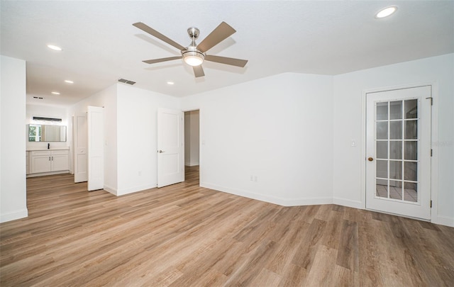 empty room with ceiling fan and light hardwood / wood-style floors