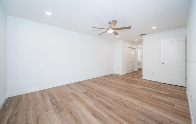 unfurnished room with light wood-type flooring, visible vents, baseboards, and recessed lighting