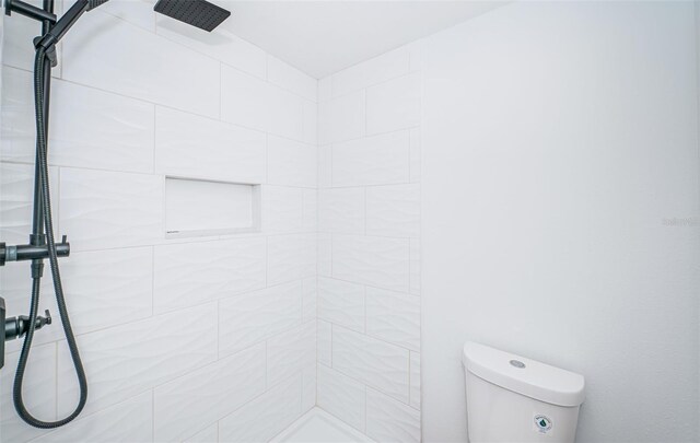 bathroom with tiled shower and toilet