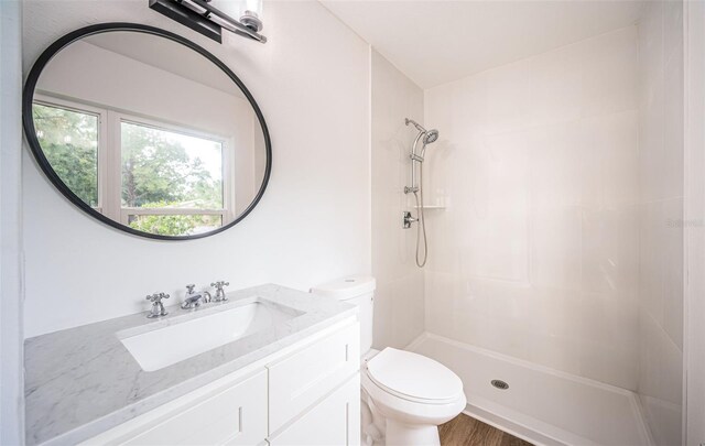 bathroom with a shower, wood-type flooring, toilet, and vanity