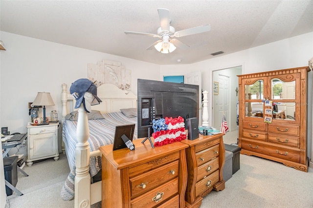 carpeted bedroom with ceiling fan and a textured ceiling