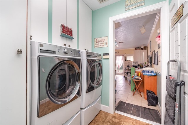 washroom with tile patterned flooring, a textured ceiling, and independent washer and dryer