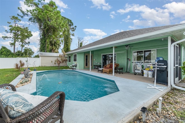 view of pool featuring pool water feature, a patio, ceiling fan, and a grill