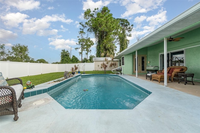 view of swimming pool featuring ceiling fan and a patio area