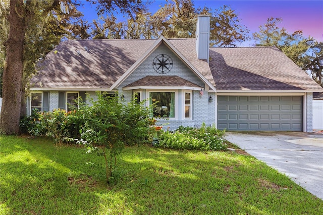 view of front of home with a lawn and a garage