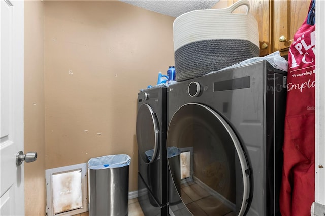 laundry room with a textured ceiling and washing machine and dryer