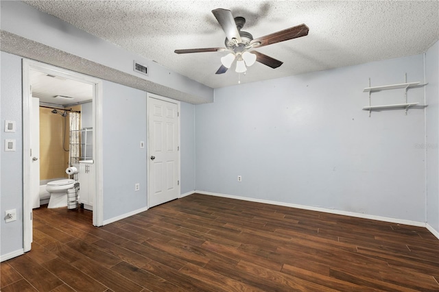 unfurnished bedroom with ceiling fan, ensuite bath, dark hardwood / wood-style floors, and a textured ceiling