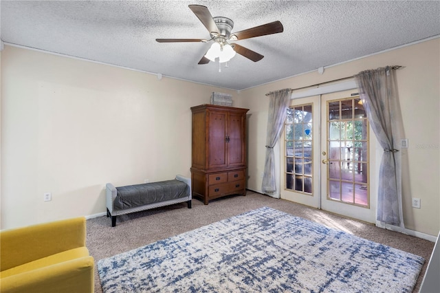 sitting room featuring french doors, light colored carpet, a textured ceiling, and ceiling fan