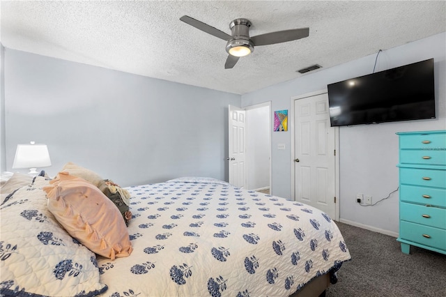 bedroom featuring dark carpet, a textured ceiling, and ceiling fan