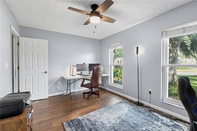 office featuring dark wood-type flooring, ceiling fan, and a textured ceiling