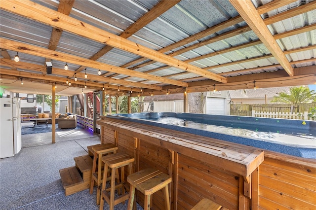 view of pool featuring exterior bar, a storage unit, and a patio area