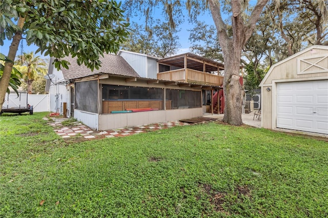 exterior space featuring an outdoor structure, a garage, a sunroom, and a lawn