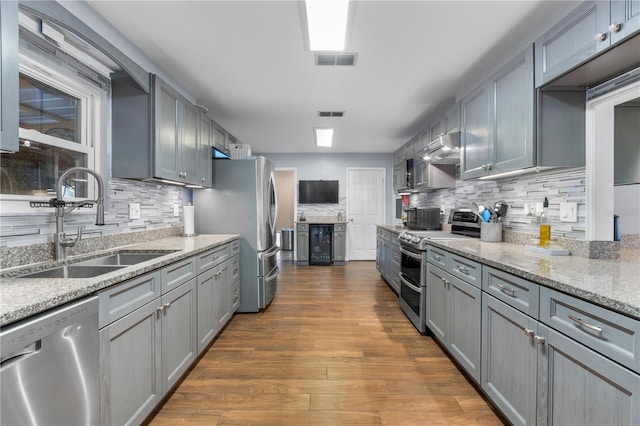 kitchen with gray cabinets, dark wood-type flooring, sink, and stainless steel appliances