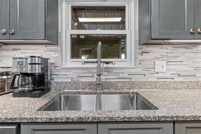 kitchen with tasteful backsplash, gray cabinets, and sink