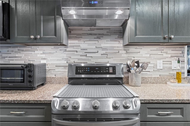 kitchen featuring ventilation hood, backsplash, stone countertops, and stainless steel range oven