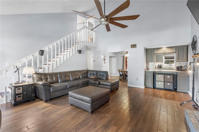 living room featuring ceiling fan, dark wood-type flooring, and high vaulted ceiling