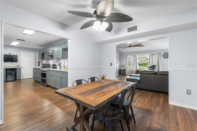 dining area featuring ceiling fan, a textured ceiling, and dark hardwood / wood-style flooring