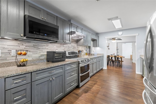 kitchen featuring stainless steel appliances, dark hardwood / wood-style flooring, tasteful backsplash, and gray cabinetry