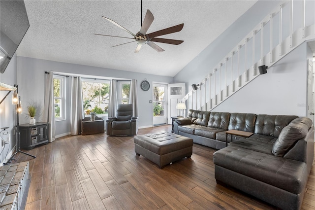 living room featuring dark wood-type flooring, ceiling fan, vaulted ceiling, and a textured ceiling