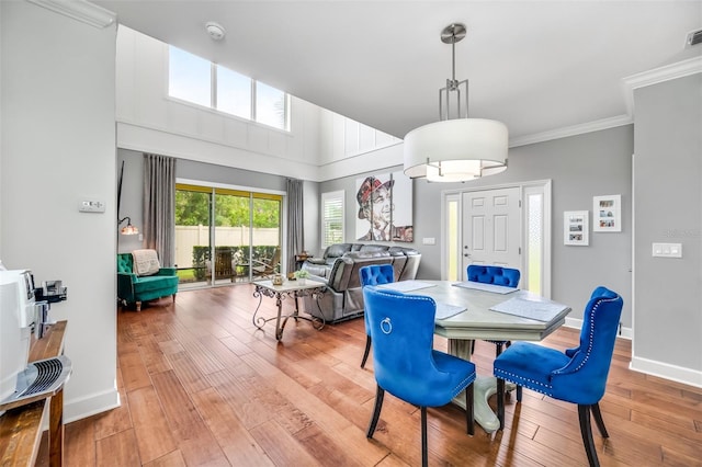 dining area with ornamental molding and hardwood / wood-style flooring