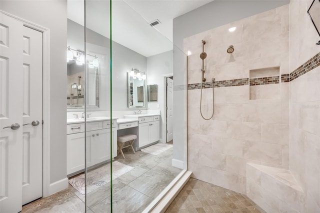 bathroom with vanity and tiled shower