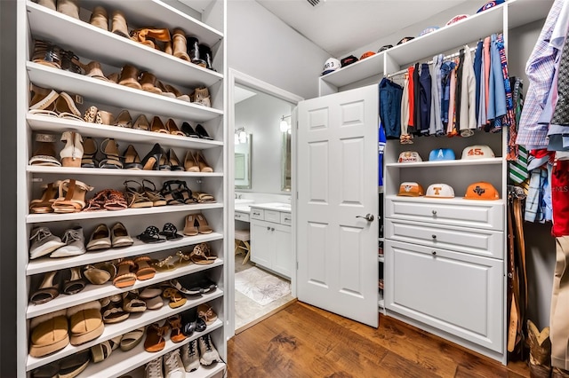 walk in closet with dark hardwood / wood-style floors