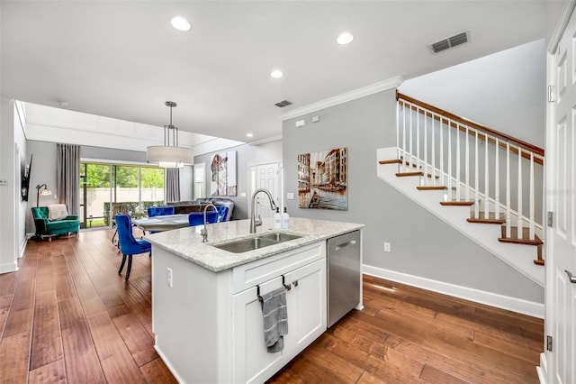 kitchen with dishwasher, light stone counters, sink, wood-type flooring, and a center island with sink