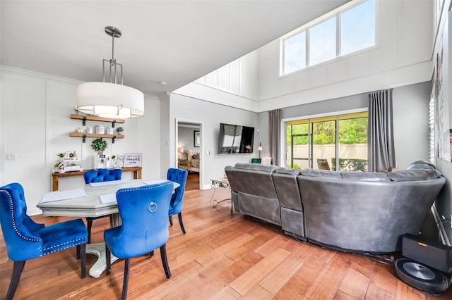 dining space featuring crown molding and light hardwood / wood-style flooring