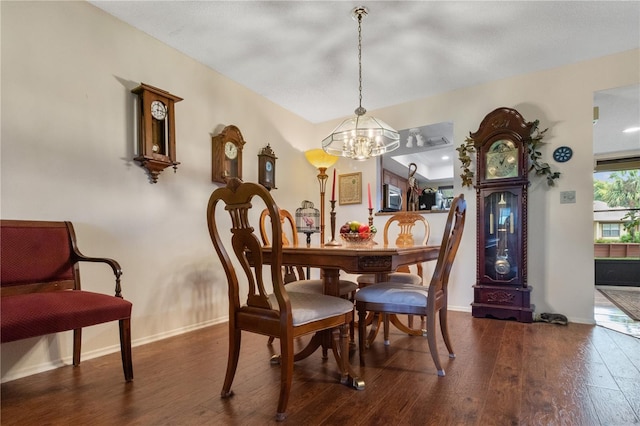 dining area with dark wood-style floors, baseboards, and a chandelier