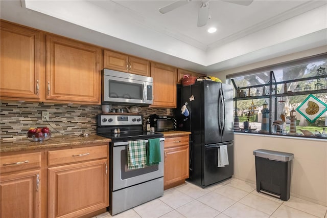 kitchen with brown cabinets, crown molding, light tile patterned floors, tasteful backsplash, and appliances with stainless steel finishes