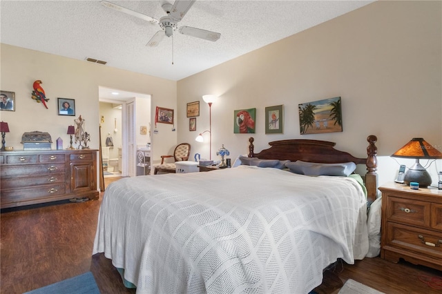 bedroom with visible vents, a ceiling fan, dark wood-style floors, ensuite bath, and a textured ceiling