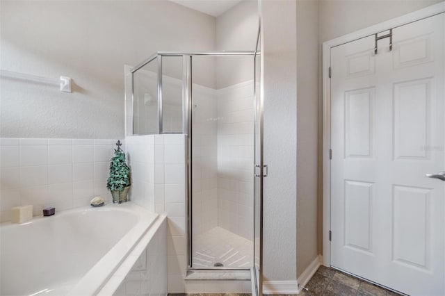 bathroom featuring shower with separate bathtub