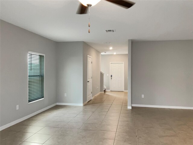 tiled empty room featuring ceiling fan