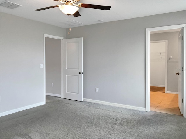 carpeted spare room featuring ceiling fan