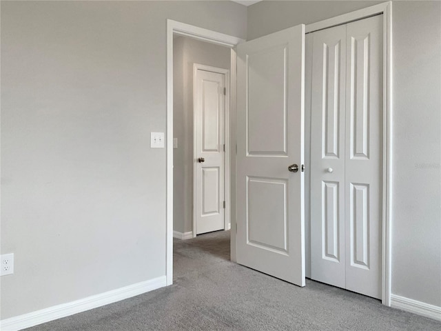 unfurnished bedroom featuring a closet and light carpet