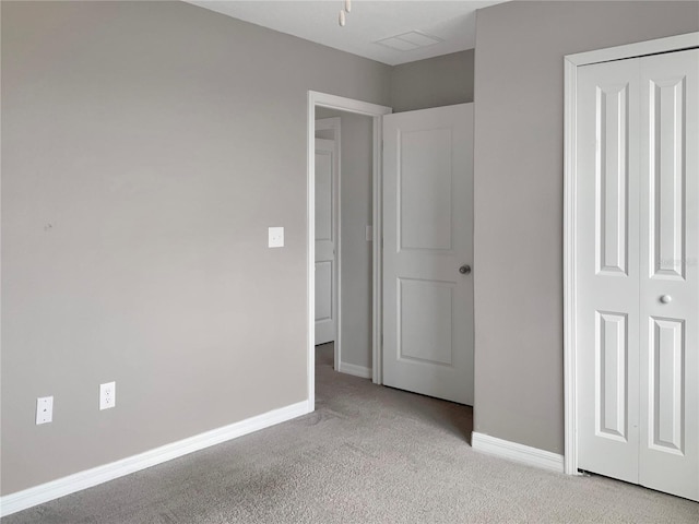 unfurnished bedroom featuring light carpet and a closet