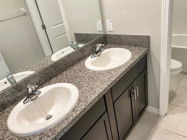 bathroom featuring vanity, toilet, tile patterned floors, and a bathtub