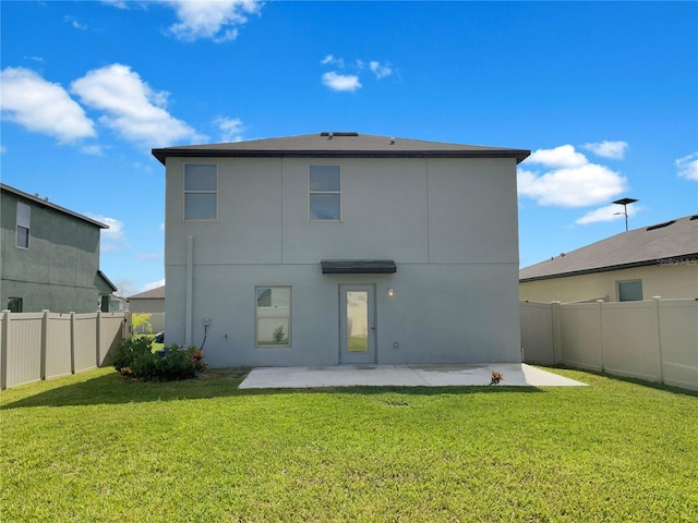 back of property with a lawn and a patio