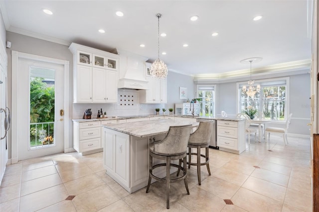 kitchen featuring pendant lighting, a center island, plenty of natural light, and white cabinetry